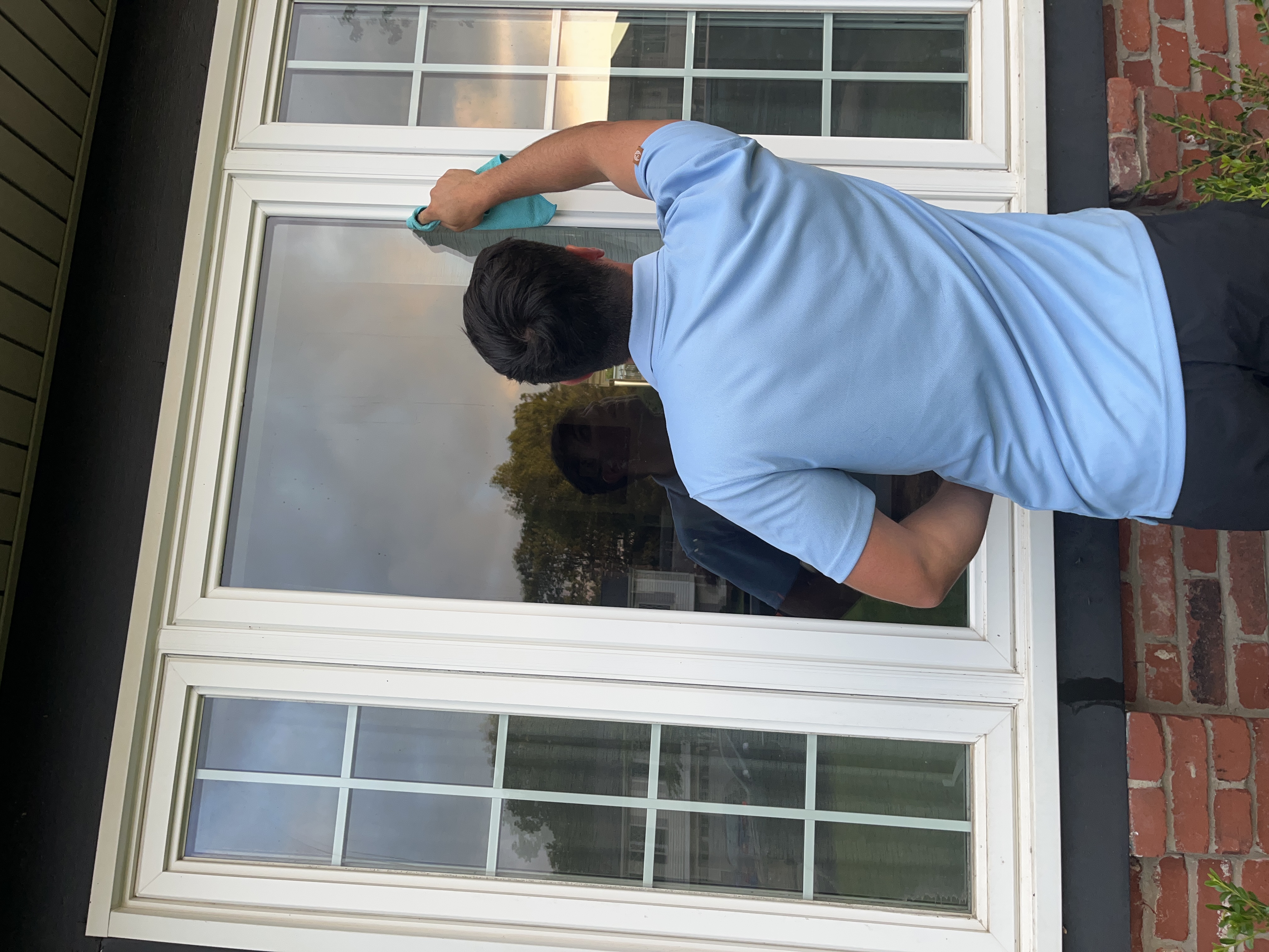 DeMoss technician detailing a window edge with a microfiber cloth