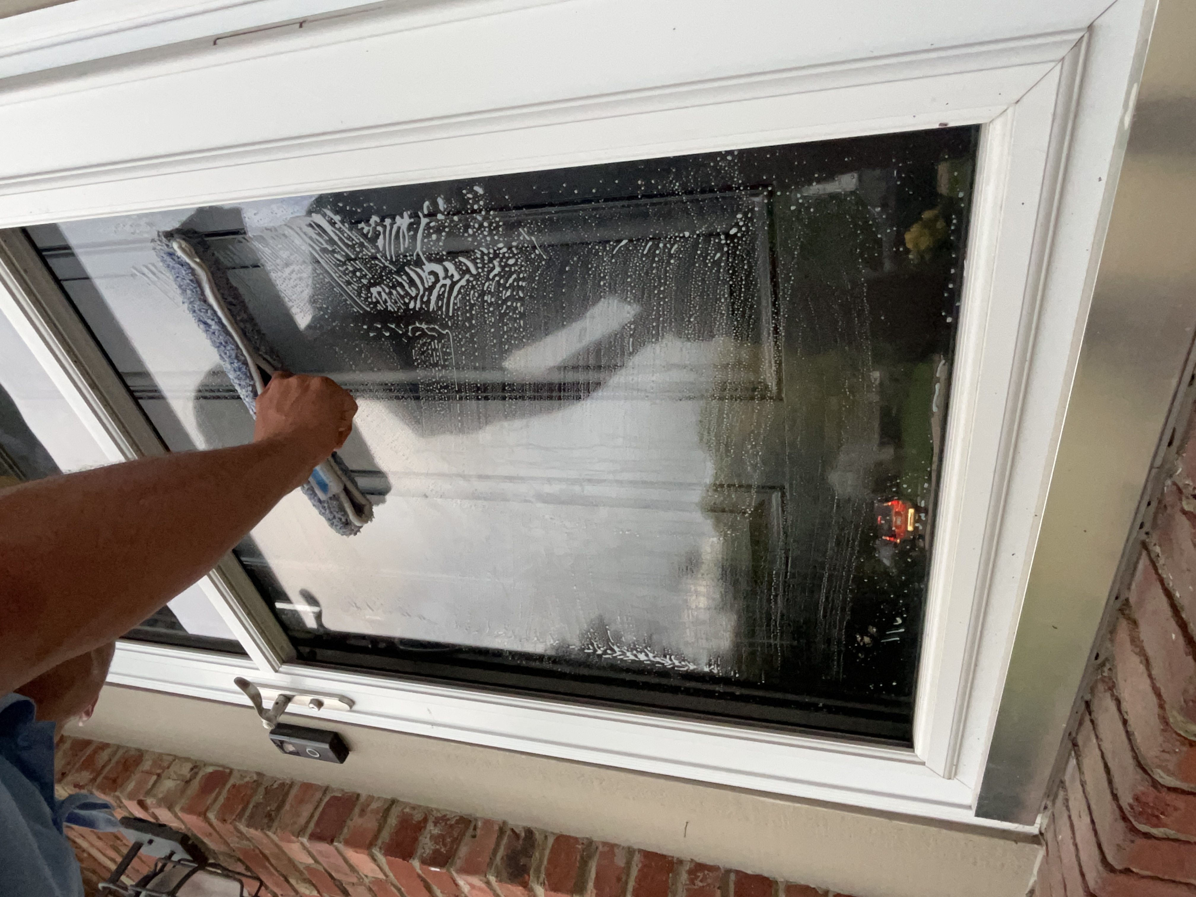 DeMoss technician scrubbing a soaped window