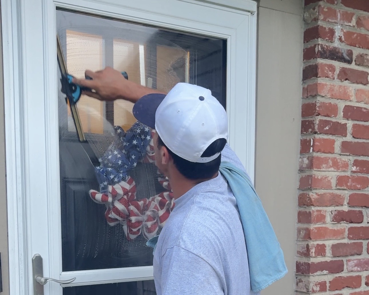 DeMoss technician squeegeeing a glass storm door